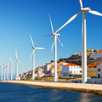 **

"A modern offshore wind farm in the Atlantic Ocean off the coast of Portugal, featuring large, next-generation wind turbines. Sunlight reflects off the water.  In the background, a coastal town with traditional Portuguese architecture.  Clear blue sky with a few wispy clouds.  Depicting clean energy, sustainability, and technological advancement.  Photorealistic, high detail."

**